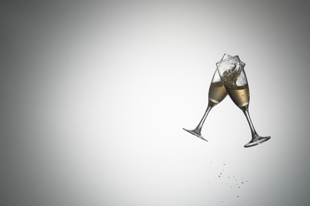 Flying wine glasses with poured alcohol on a gradient background. A sparkling wine. White wine. Champagne. Alcoholの写真素材