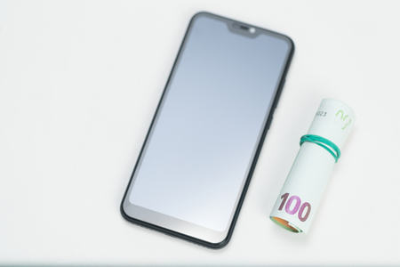 Finance. Money. Euro. Rubles. Dollar bills and smartphone on a white background. Top view. Studio lightの写真素材