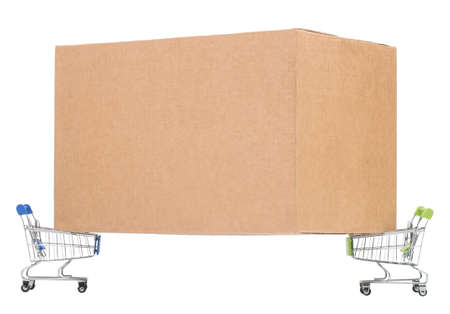 Corrugated cardboard packaging box rests on two toy shopping carts on isolated white backgroundの写真素材