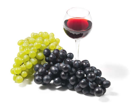 Two clusters of white and black grapes and glasses with red wine on an isolated white background studio lightingの写真素材