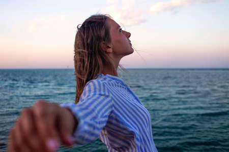 Woman enjoying freedom. Standing arms outstretched back and enjoy life on the beach at sea under...
