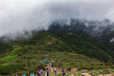 Tourist trail with a lot of tourists. Scenic view of mountains against sky. Stone road to nowhere in...