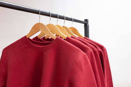 Blank sweatshirts hanging on a hanger in the wardrobe or showroomの写真素材
