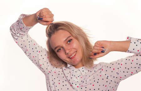 Blonde young woman face expression with pierced nose clean fresh skin posing on a white backgroundの写真素材