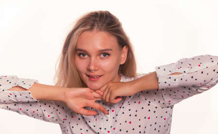 Blonde young woman face expression with pierced nose clean fresh skin posing on a white background