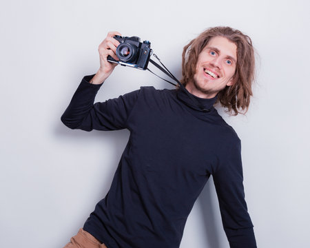Young dreadlocks man using vintage camera and smiling happy with open mouth on gray background copy spaceの写真素材