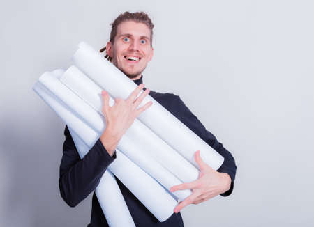 Dreadlocks man holds blueprints in hands loaded with projects or overwhelmed with work. Drops out of...