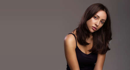 Hair or skin care concept. Portrait of a luxurious young woman with healthy hair and skin on studio...