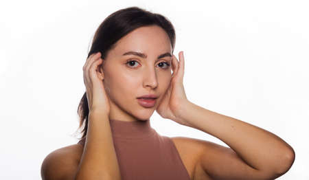 Beautiful face of young woman with clean fresh skin standing in short turtleneck. Beauty portrait of...