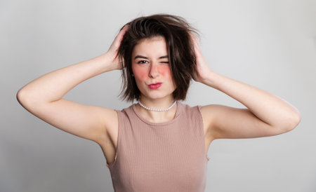 It's time to go to the beauty salon. Casual woman face expressions she does not go to spa, hair salon or beauty salon for long time. over gray background copy space.の写真素材