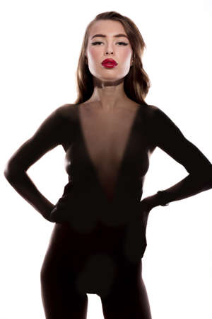 Art fashion surrealistic portrait of beautiful nude woman with light on her face and shadow on her body isolated on whiteの写真素材