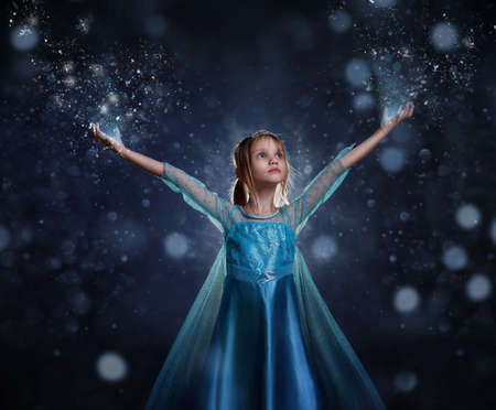 Young girl snow princess. Mystery fantasy girl in blue lush dress. Art background winter frozen and...