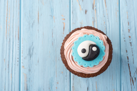 A beautiful capkake with eastern symbols on a blue tableの写真素材
