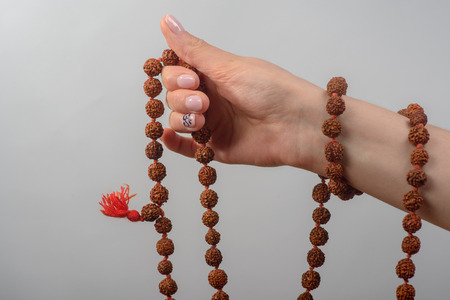 Hand with a rosary on a gray backgroundの写真素材