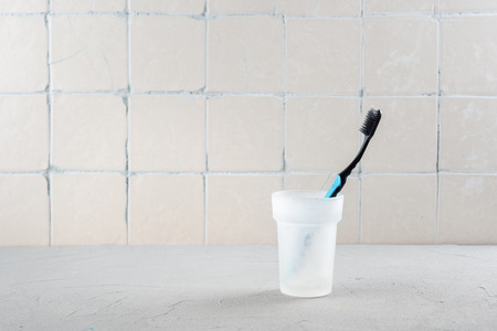 Toothbrush in the bathroom against the wall with ceramic tilesの写真素材