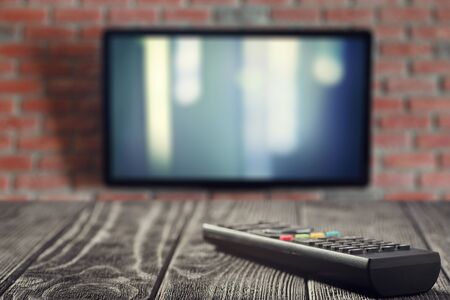 TV remote and TV on the table close-upの写真素材