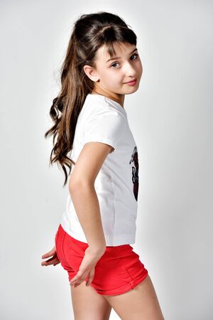 Beautiful smiling model standing sideways in red shortsの写真素材