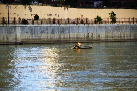 view of the river with a fisherman on a boat catch fish;の写真素材