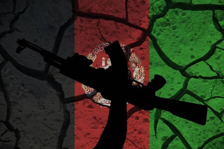 Afghanistan flag on the background texture of cracked earth and silhouette of a hand with a vent. The concept of design solutions.の写真素材