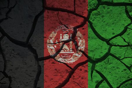 Afghanistan flag on the background texture of cracked earth. The concept of design solutions.の写真素材