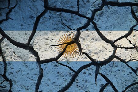 Argentina flag on the background texture of cracked earth. The concept of design solutions.