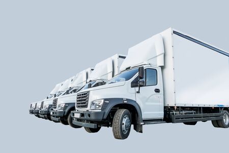 Five white truckers in the parking lot are waiting for the next delivery of goods. The concept of a...