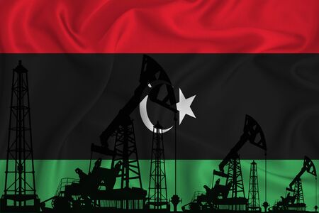 Developing Flag of Libya. Silhouette of drilling rigs and oil rigs on a flag background. Oil and gas industry. The concept of oil fields and gas and oil companies. 3D rendering.の写真素材