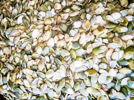 Macro photo, delicious pumpkin seeds. Summer tray agricultural farm market full of organic...