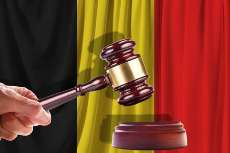Judge wooden gavel on the background of the flag of Belgium. Oil and gas industry. The concept of oil fields and oil companies.の写真素材