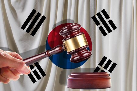 Judge wooden gavel on the background of the flag of South Korean. Oil and gas industry. The concept of oil fields and oil companies.の写真素材