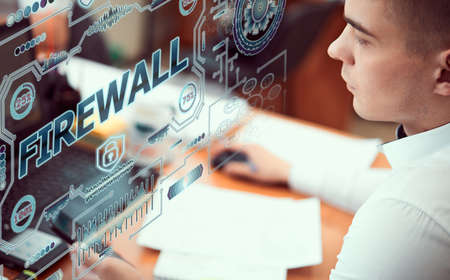 Concept business, technology, blockchain, internet and future network concept of computers. Young man works with neon hologram screen. On the screen of the hologram the inscription: Firewallの写真素材