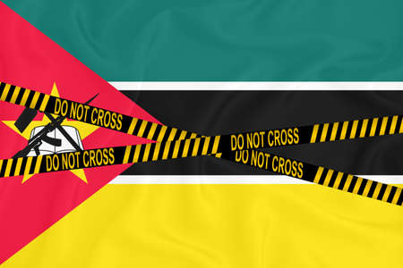 Mozambique flag, the Don't Cross the Line mark and the location tape. Crime concept, police investigation, quarantine. 3d renderingの写真素材