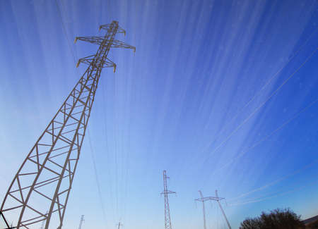 Electric transmission line. Power transmission pylon silhouette against blue sky at dusk. The...