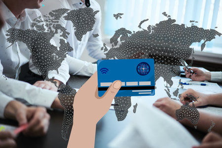 hand holds a credit card against the background of the world map and people sitting at the table. Contactless payment conceptの写真素材