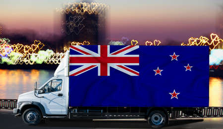 New Zealand flag on the side of a white van against the backdrop of a blurred city and river. Logistics conceptの写真素材