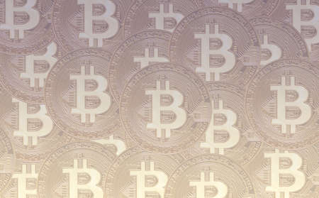 Gold crypto coin bitcoin (btc) sign, against the background of bitcoin tanned coins.