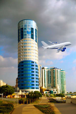 Commercial white plane airliner flying over the city. Travel concept.の写真素材