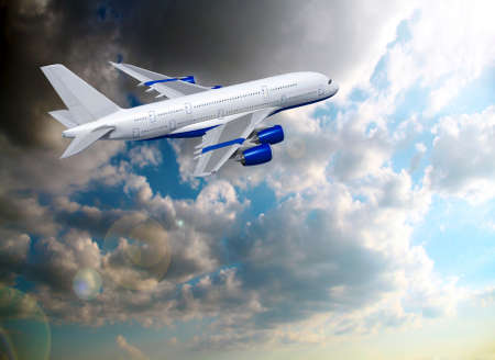 Commercial white plane airliner flying over dramatic clouds. Travel concept.の写真素材