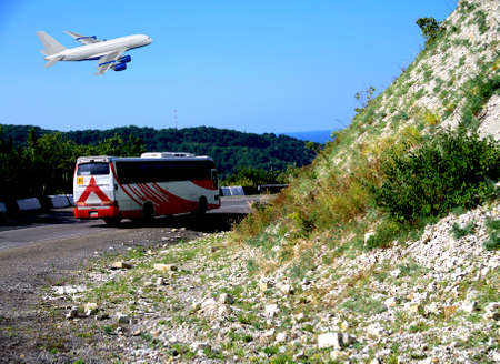 Commercial white plane airliner flying over dramatic clouds and mountains. Travel concept.の写真素材