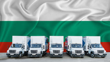 Bulgaria flag in the background. Five new white trucks are parked in the parking lot. Truck, transport, freight transport. Freight and logistics conceptの写真素材