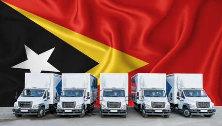 timor flag in the background. Five new white trucks are parked in the parking lot. Truck, transport, freight transport. Freight and logistics conceptの写真素材