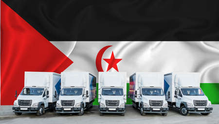 Western Sahara flag in the background. Five new white trucks are parked in the parking lot. Truck, transport, freight transport. Freight and logistics conceptの写真素材