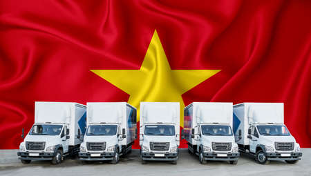 Vietnam flag in the background. Five new white trucks are parked in the parking lot. Truck, transport, freight transport. Freight and logistics conceptの写真素材