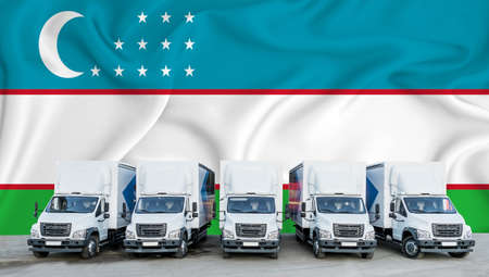 Uzbekistan flag in the background. Five new white trucks are parked in the parking lot. Truck, transport, freight transport. Freight and logistics conceptの写真素材