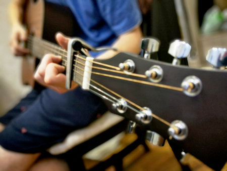 Hands of a man playing the guitar. Bending technique. Low key photo.の写真素材