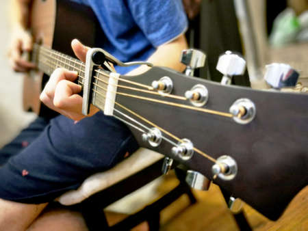 Hands of a man playing the guitar. Bending technique. Low key photo.の写真素材