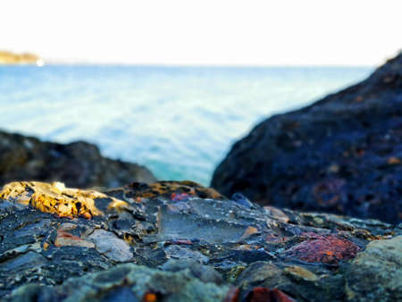pebbles by the sea. Silky blue sea waves from long exposure. Stones on the Black Sea coast in cloudy weather against the background of the gray sea and sky in the Krasnodar Territoryの写真素材