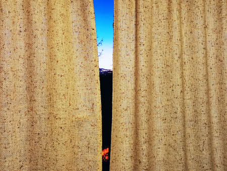 The shadow of the sunset on the forehead curtains, the view from the window on the outskirts of the city, the silhouette of trees, the blue sky at sunset.の写真素材