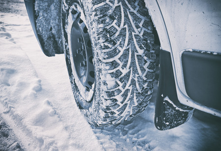 Car's tire covered by snowの写真素材