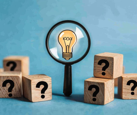 Concept illustration of a glowing light bulb under a magnifying glass among cubes with question marks symbolizes thinking and ideasの素材